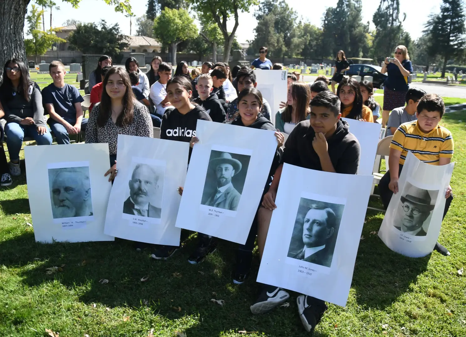 Madera Unified School district students hold posters of past Madera County Sheriffs during a presentation for “Outlaws and Lawmen: Crimes of the Century and the Madera County Sheriffs who Solved Them.”